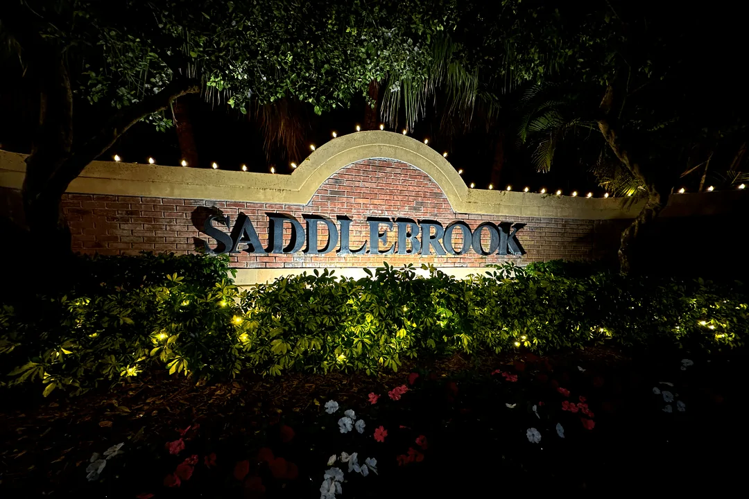 Saddlebrook brick monument sign with landscape lighting at night