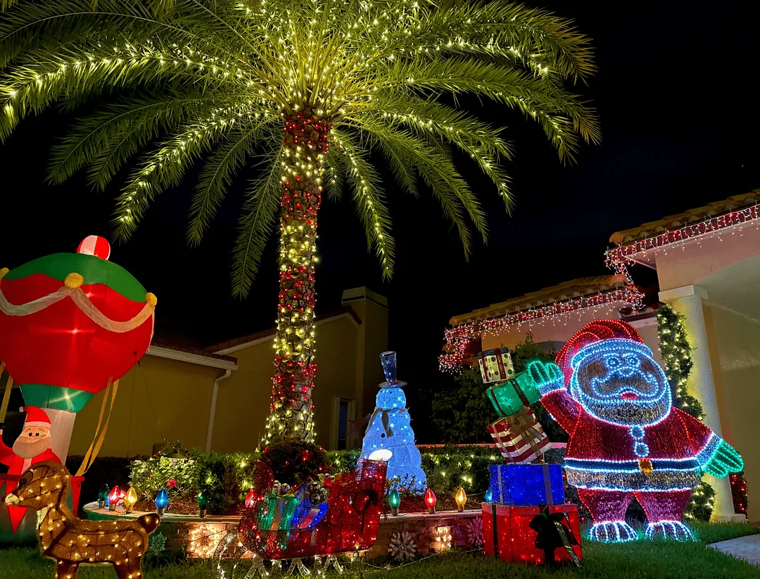 Christmas display with a lit palm, Santa and gift inflatables