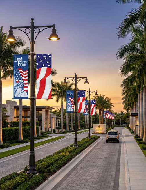 American flag banners displayed along a community entrance at night