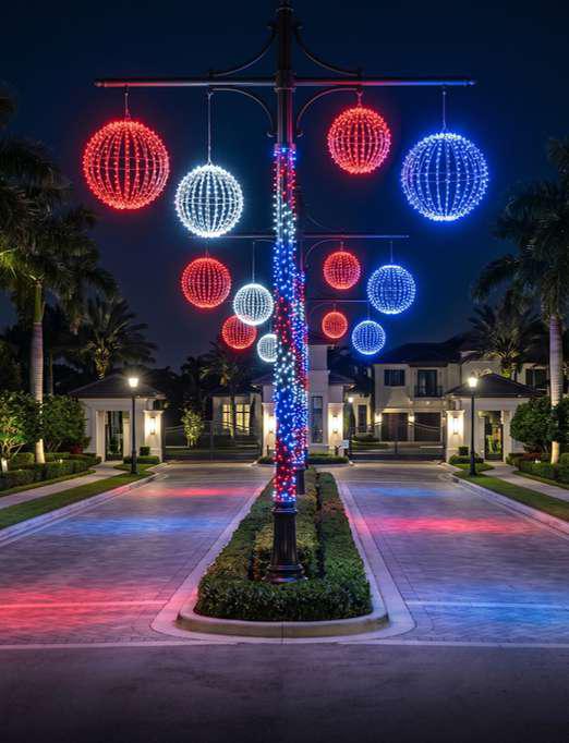 Red, white, and blue illuminated light spheres at a community entrance